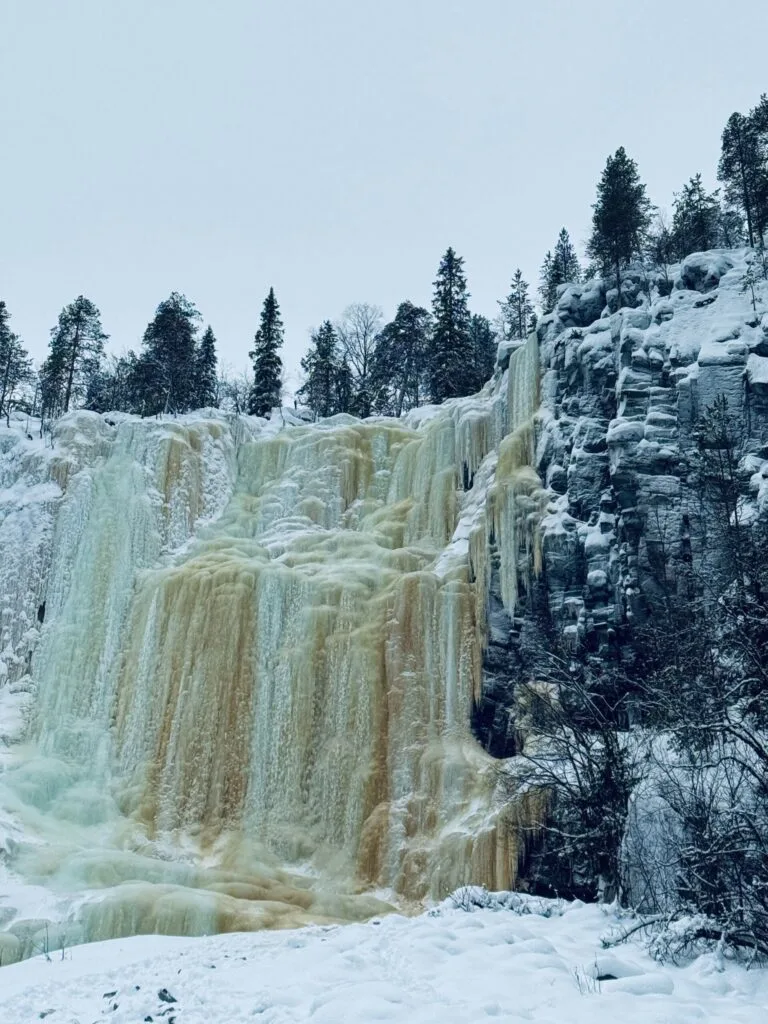 Frozen waterfall cascading through the snow-covered Korouoma canyon in winter